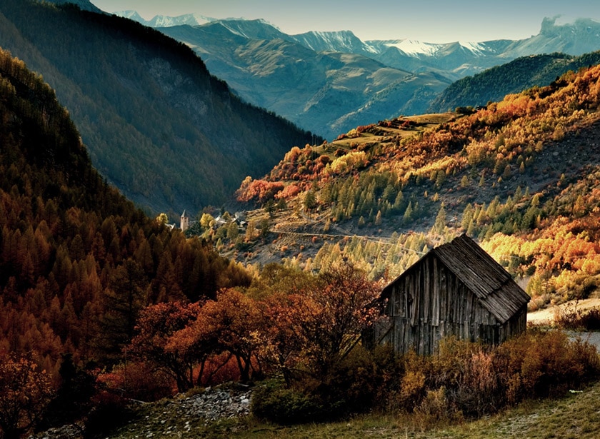 An alpine valley in Autumn, all reddish-orange in colours.
